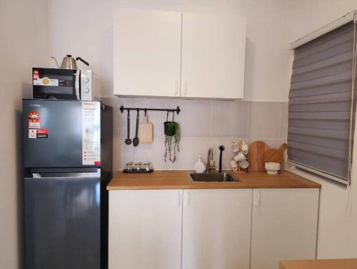 a kitchen with a stainless steel refrigerator and a sink at Qai's Nest in Kampung Dengkil