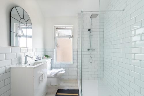 a white bathroom with a sink and a shower at Sophia's Retreat - 2 Floor 4 Bed Apartment - Newport - Coastal Getaway in Newport