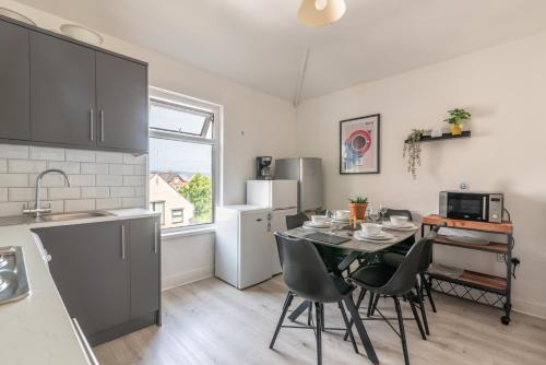 a kitchen and dining room with a table and chairs at Sophia's Retreat - 2 Floor 4 Bed Apartment - Newport - Coastal Getaway in Newport