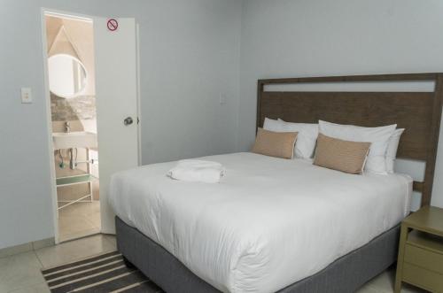 a bedroom with a large bed with white sheets and pillows at Oceanic Unit 99 - North Beach in Durban