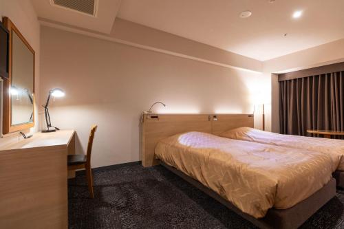 a hotel room with a bed and a desk at Hotel Regina Kawaguchiko in Fujikawaguchiko