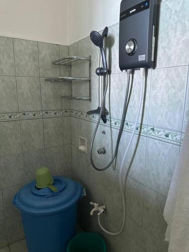 a shower in a bathroom with a blue toilet at Tubod Mar Terraza 3 bedrooms and basement up to 18 pax in Larapan