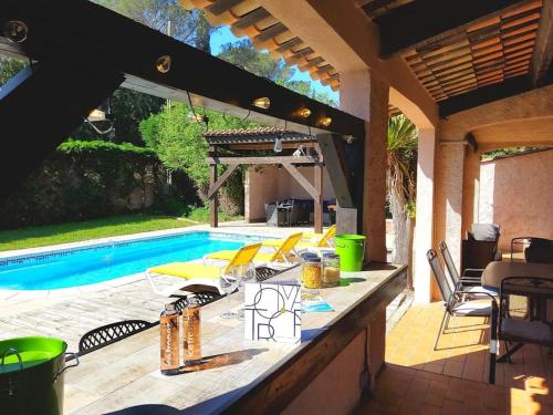 un patio avec une table à côté d'une piscine dans l'établissement 105m2, piscine, 5 min des golfs, proche centre, à Saint-Raphaël