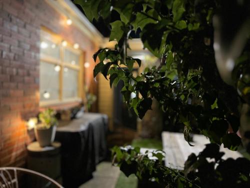 a room with a table and a window and a plant at Treehouse Hideouts - Ground Level - Heygarth House Townhouse - Port of Echuca in Echuca