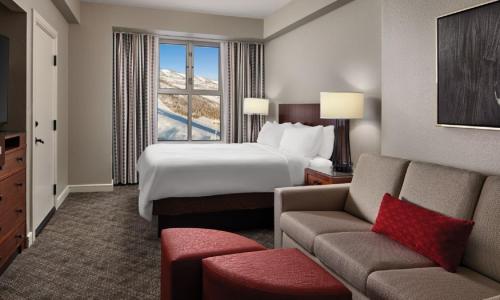 ein Hotelzimmer mit einem Bett, einer Couch und einem Fenster in der Unterkunft Marriott Mountainside Luxury Studio in Park City