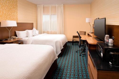 a hotel room with two beds and a desk at Fairfield Inn & Suites by Marriott Albany East Greenbush in East Greenbush