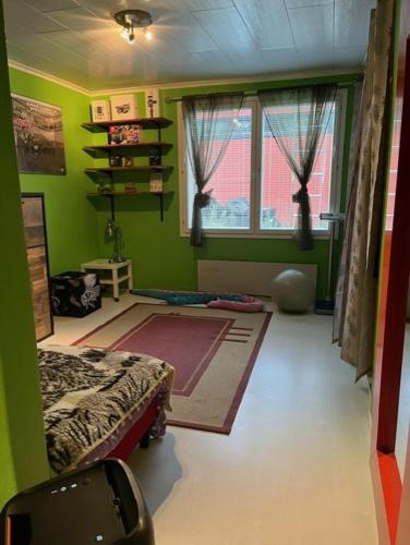 a green room with a bed and a window at Sweet House with Sauna in Lieto