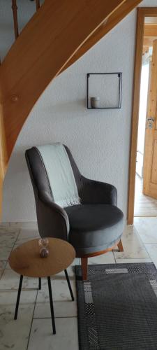 a living room with a leather chair and a table at Gästehaus Fechtig in Hergensweiler