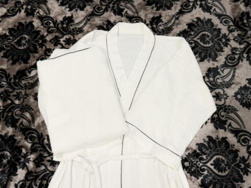 a white robe with a necklace on a wall at Hotel BaliBali Matsudo in Matsudo