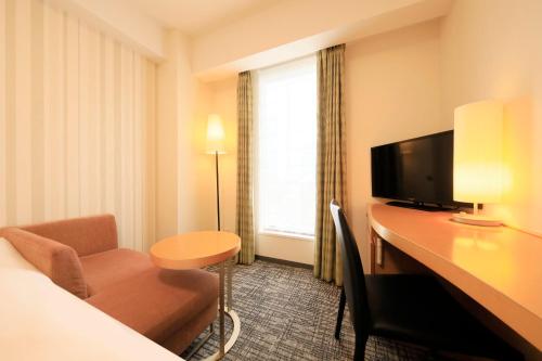a hotel room with a desk and a television at Richmond Hotel Premier Sendai Ekimae in Sendai