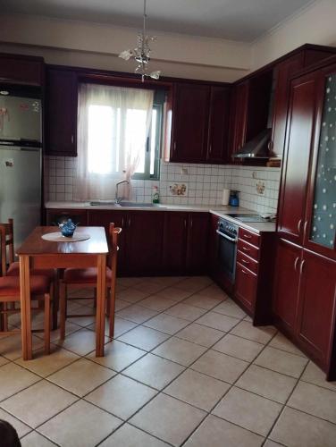 a kitchen with wooden cabinets and a table and a window at Studio eva in Palouki