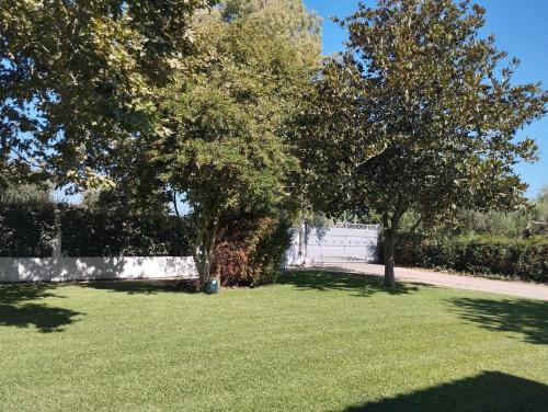 a field of grass with trees and a fence at Studio eva in Palouki