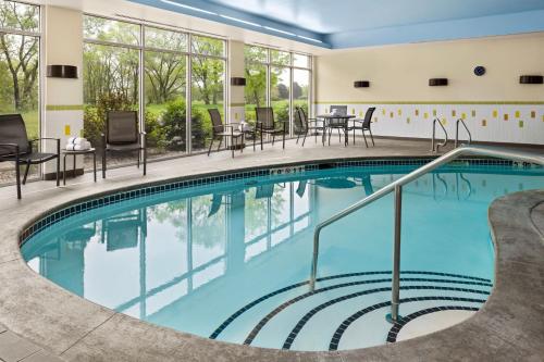 a pool in a hotel with tables and chairs at Fairfield Inn & Suites by Marriott Waterloo Cedar Falls in Waterloo