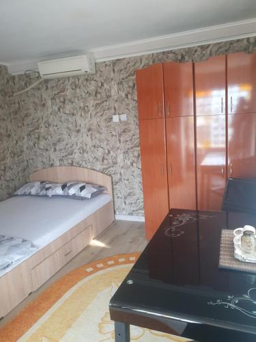 a bedroom with a bed and a cabinet and a table at Casa Marco in Galaţi