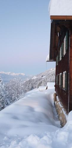 a building covered in snow with a pile of snow at Haus Mura in Blons
