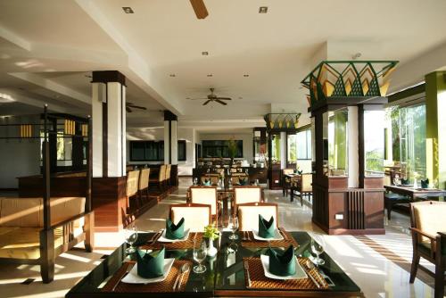 een restaurant met tafels en stoelen in een kamer bij Palm Paradise, Aonang Resort in Ao Nang Beach