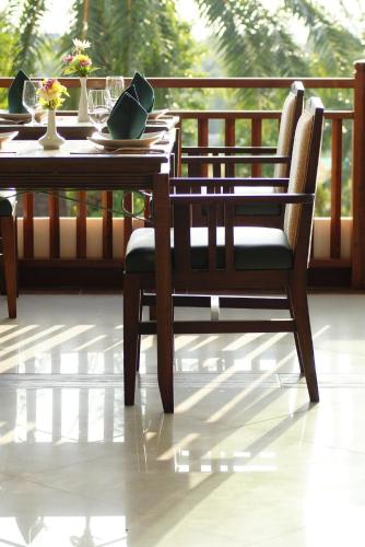 een houten tafel en stoel op een veranda bij Palm Paradise, Aonang Resort in Ao Nang Beach