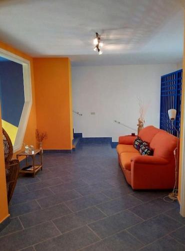 a living room with an orange couch in a room at La Taverna dei Colori in Laurino