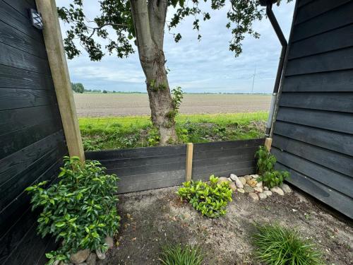 a wooden fence with a tree in a field at Elefteria in Kolhorn