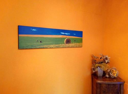 a painting on an orange wall with animals in a field at La Taverna dei Colori in Laurino