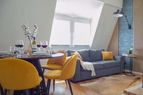a living room with a couch and a table with yellow chairs at Designerwohnung nahe der Wasserfälle in Triberg