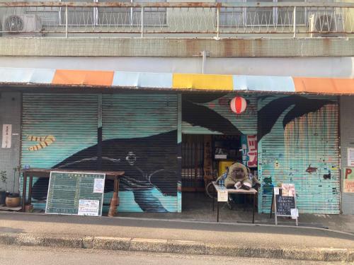 a store window with a painting of a dog on it at IG3 宇佐美駅近海近の完全貸切ビーチハウス お宿三感四温 Oyado Sankanshion in Ito