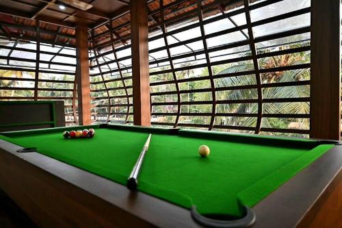 a pool table in a room with a large window at Riverbliss - River Retreat with Private Pool in Talavadi