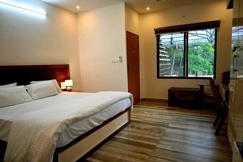 a bedroom with a large bed and a window at Riverbliss - River Retreat with Private Pool in Talavadi