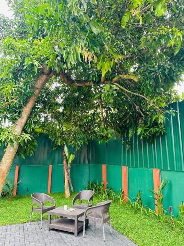 two chairs and a table next to a tree at Riverbliss - River Retreat with Private Pool in Talavadi