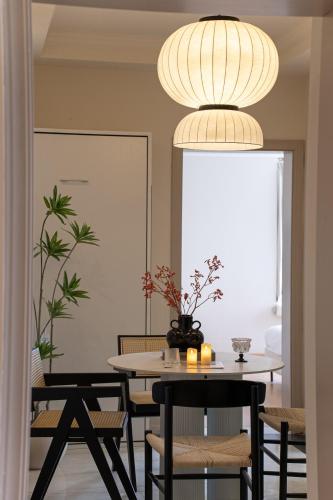 a dining room with a table and chairs and a light fixture at Moli B&B - The Bund Riverview Nanjing East Road 3-Bedrooms with Elevator Apartment Near the subway in Shanghai