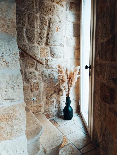a vase sitting next to a brick wall with a window at PALAZZO CAVÌ in Mola di Bari