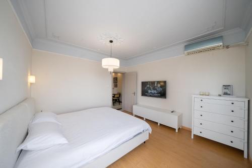 a white bedroom with a white bed and a dresser at Moli B&B - The Bund Riverview Nanjing East Road 3-Bedrooms with Elevator Apartment Near the subway in Shanghai