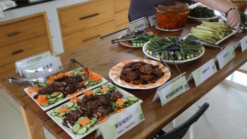 a table with several plates of food on it at Hakka Eco-farm 雅歌園民宿食農教育有機農場 in Wanluan