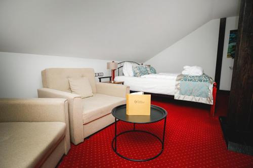 a living room with a couch and a table at Zámek Wichterle - Hotel a pivní lázně in Slavičín