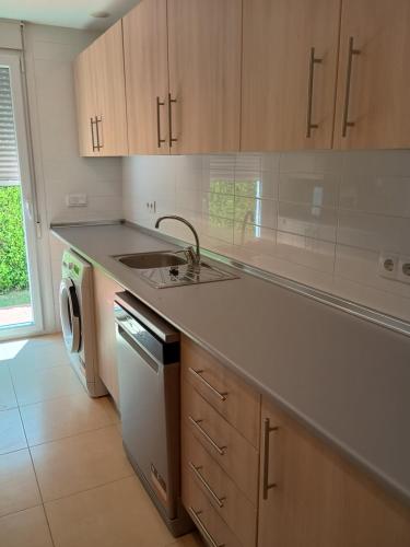 een keuken met een spoelbak en een wasmachine bij Condado de Alhama Golf resort - Villa Alba in Alhama de Murcia