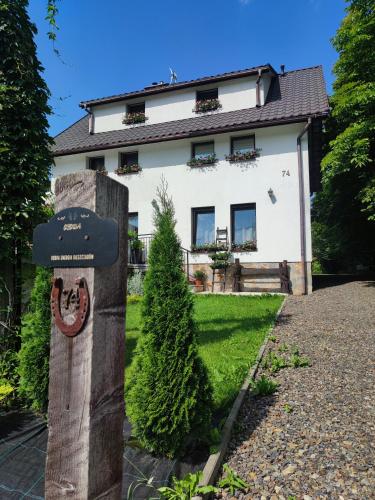 a house with a sign in front of it at O'Sowa Noclegi Wetlina in Wetlina