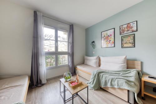 une petite pièce avec un lit et une fenêtre dans l'établissement Cosy Home / Disney / Val d'Europe / Paris, à Serris