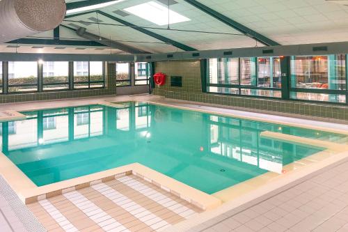 une grande piscine dans un immeuble dans l'établissement Cosy Home / Disney / Val d'Europe / Paris, à Serris