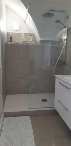 a bathroom with a shower with a glass door at La Tour Noble in Saint-Saturnin