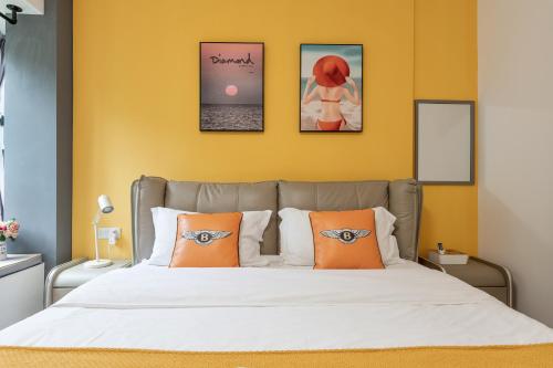 a bedroom with a bed with two orange pillows at Guangzhou He She Art Apartment in Guangzhou