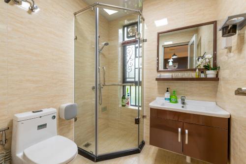 a bathroom with a shower and a toilet and a sink at Guangzhou He She Art Apartment in Guangzhou