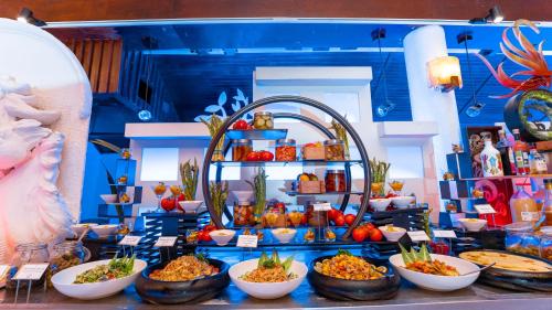 a buffet with bowls of food on a table at Lily Beach Resort and Spa - All Inclusive in Dhangethi