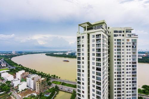 an aerial view of a tall white building next to a river at Diamond Island - Mekong Retreat Apartment in Ho Chi Minh City