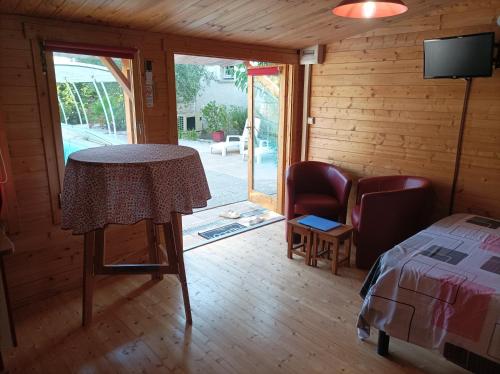 a bedroom with a table and a bed and a television at KITOKO L'HERAULT gite close to SALAGOU Lake in Clermont-lʼHérault