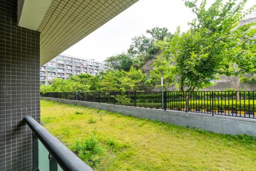 a fence next to a field of grass next to a building at Guangzhou He She Art Apartment in Guangzhou