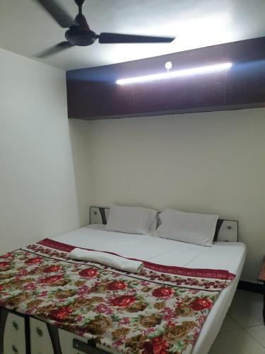 a bed in a room with a ceiling fan at Dream Vision Guest House in Diu