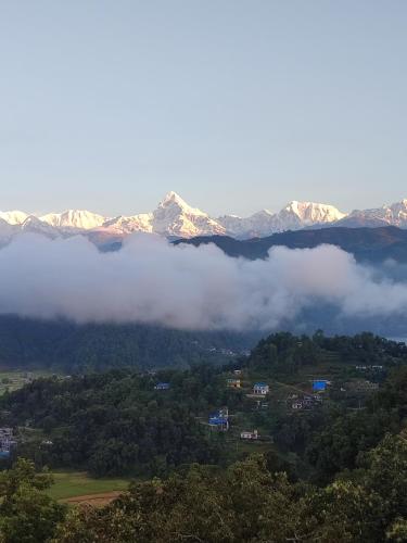a foggy valley with mountains in the background at Hotel Lekhnath View Tower and Eco Farm in Deorāli