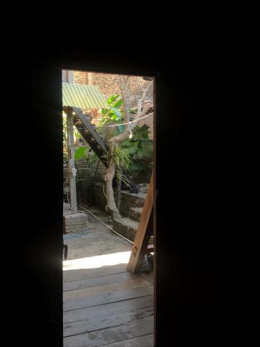 an open door to a yard with a tree at Omah Guyub in Ngabean