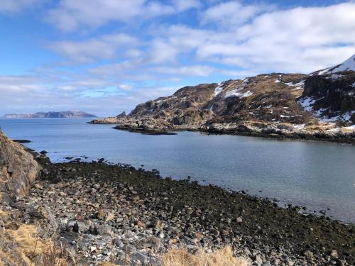 a body of water with mountains in the background at Andsnes Velhus in Loppa