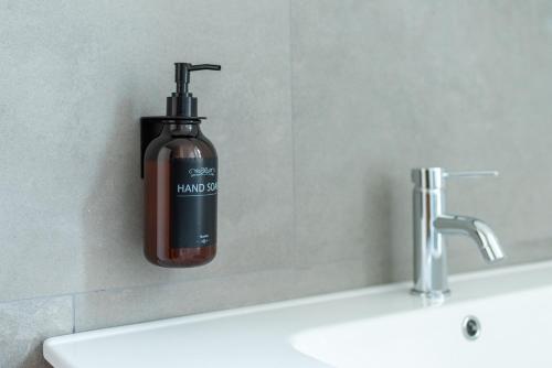 a soap dispenser on a wall next to a sink at Naviglio suite apartments in Robecco sul Naviglio